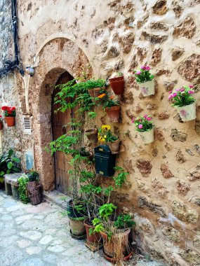 İspanya, Malaga 'da tipik bir sokak, renkli çiçeklerle süslenmiş taş cephelerle.