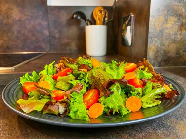 Marul, domates ve havuçtan yapılmış taze salata tabağı..