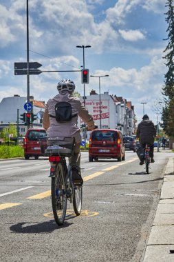 Berlin, Almanya - 8 Mayıs 2021 Berlin 'de bisikletçiyle sokak sahnesi. Döngü yolu, bisikletçilere trafikte daha fazla yer açmak için geçici olarak boyandı.