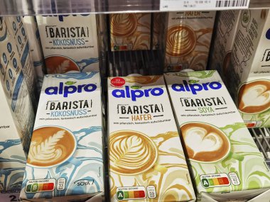 Berlin; Germany - June 10; 2021: View to a shelf with packages of vegan milk beverages in a supermarket.