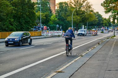 Berlin, Almanya - 10 Eylül 2021: Berlin 'de bisikletçiyle sokak sahnesi. Bisiklet yolu bisikletçilere trafikte daha fazla yer vermek için boyandı.