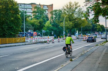 Berlin, Almanya - 10 Eylül 2021: Berlin 'de bisikletçiyle sokak sahnesi. Bisiklet yolu bisikletçilere trafikte daha fazla yer vermek için boyandı.