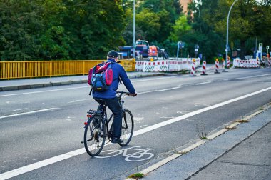 Berlin, Almanya - 10 Eylül 2021: Berlin 'de bisikletçiyle sokak sahnesi. Bisiklet yolu bisikletçilere trafikte daha fazla yer vermek için boyandı.