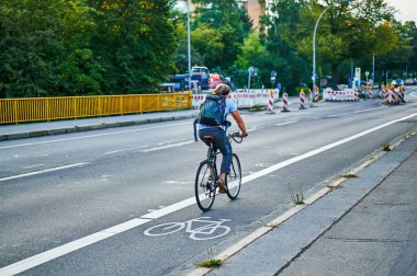 Berlin, Almanya - 10 Eylül 2021: Berlin 'de bisikletçiyle sokak sahnesi. Bisiklet yolu bisikletçilere trafikte daha fazla yer vermek için boyandı.