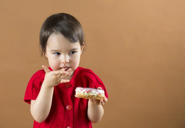 Menina bonito comendo donuts doces — Fotografia de Stock