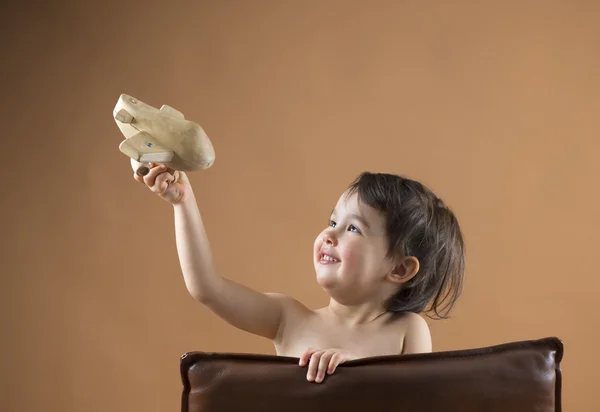 Happy kid playing with toy airplane. Studio shot — Stock Photo, Image