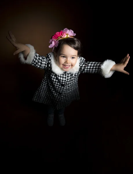 Happy beautiful little girl screaming with her hands up on black background, studio shot. Little girl playing — Stock Photo, Image