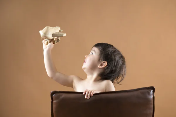 Šťastné dítě hraje s hračkou letadla. Studio záběr. — Stock fotografie