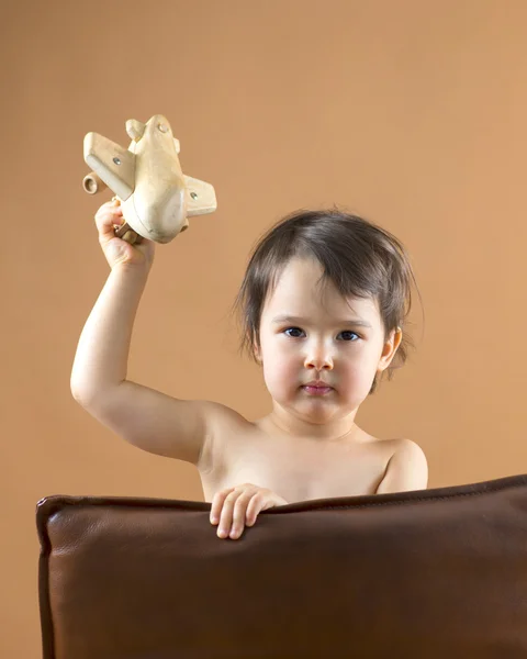 Gelukkig kind spelen met speelgoed vliegtuig. Studio schoot. — Stockfoto