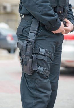 ve bir polis memuru, silahı kılıfından detay