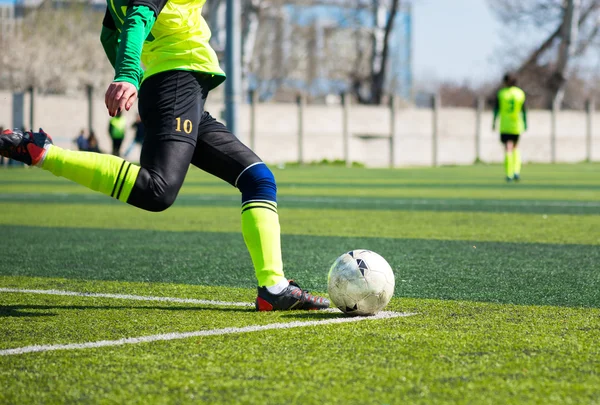 Детальное изображение ноги женщины футболиста, когда пинает мяч — стоковое фото