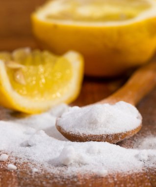 kabartma tozu (sodyum bikarbonat) bir tahta kaşık ve limon