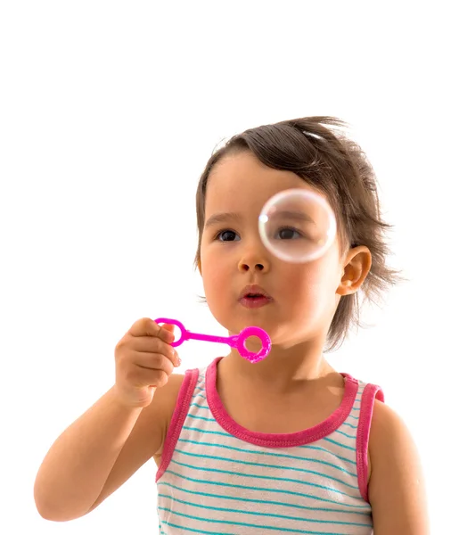 Menina sopra sabão bolhas sobre fundo branco — Fotografia de Stock