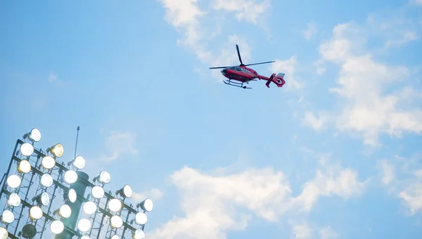 Helicóptero voador sobre fotball holofotes virou ao pôr do sol — Fotografia de Stock