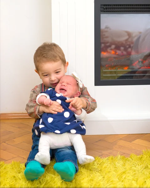 Bror håller sin nyfödda lillasyster — Stockfoto