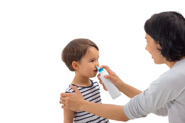 A mão dos pais de uma menina aplica um spray nasal — Fotografia de Stock