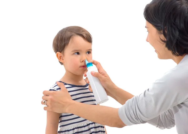 Förälderns hand om en flicka gäller nässpray — Stockfoto