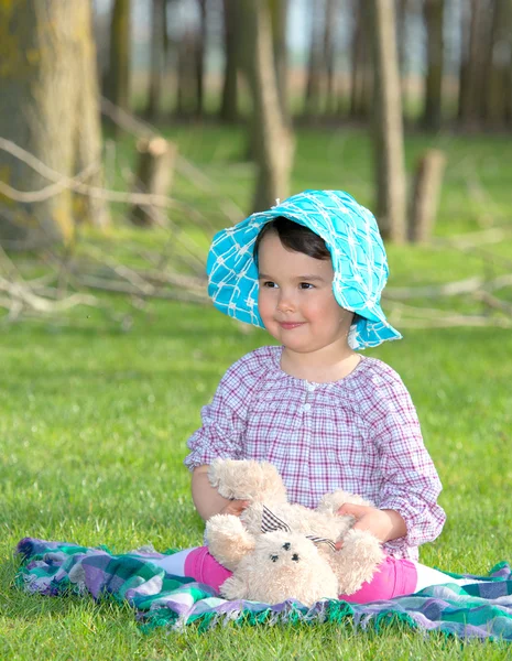 Little girl with teddy bear on nature — Stock Photo, Image