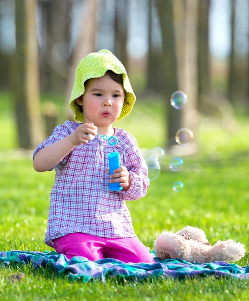 Retrato de engraçado linda menina soprando bolhas de sabão — Fotografia de Stock