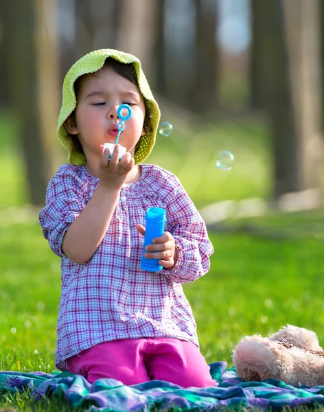 Portrait of funny lovely little girl blowing soap bubbles — Stock Photo, Image