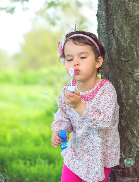 Potret lucu gadis kecil yang cantik meniup gelembung sabun — Stok Foto