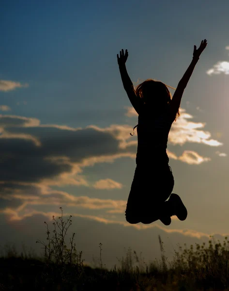 Mladá dívka, která skočila v západu slunce světlo — Stock fotografie
