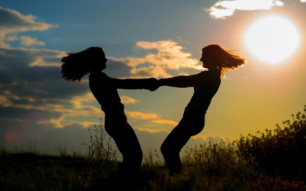 Duas menina bonita se divertindo juntos ao pôr do sol — Fotografia de Stock