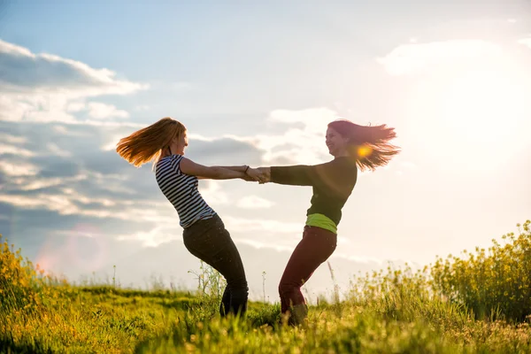 Két gyönyörű lány szórakozás együtt a naplementekor — Stock Fotó