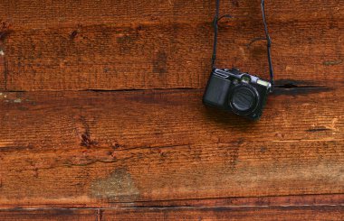 Ahşap bir duvarda asılı vintage dijital kompakt fotoğraf makinesi