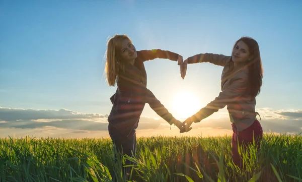 Zonsondergang hart gemaakt door twee meisjes — Stockfoto