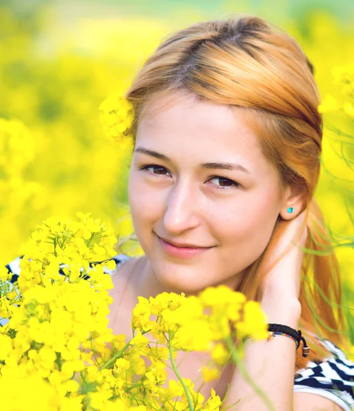 Retrato de una hermosa chica en el campo de colza — Foto de Stock