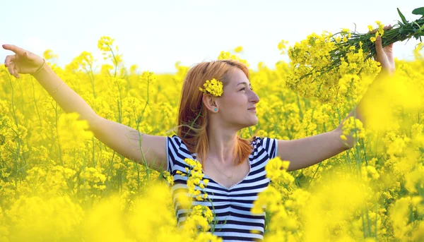 Retrato de una hermosa chica en el campo de colza — Foto de Stock