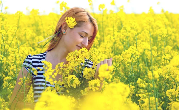 Retrato de una hermosa chica en el campo de colza — Foto de Stock