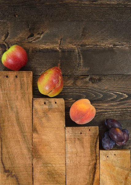 Obstsortiment liegt auf dem rustikalen Holztisch. — Stockfoto