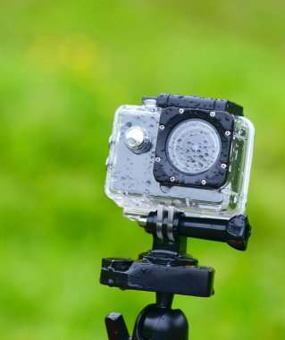 Yeşil arka plan üzerinde eylem fotoğraf makinesi ile yağmur damlaları