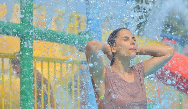 美丽女人享受下成千上万的滴在背景中的水射流 — 图库照片