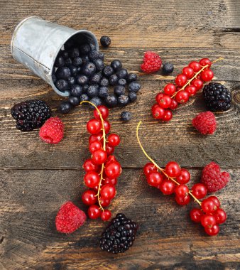 Yaban mersini, frenk üzümü ve blackberry üzerinde ahşap arka plan karıştırın