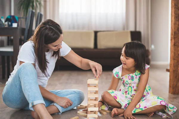 若いです母とともに彼女の小さな娘ゲームで木のブロック — ストック写真