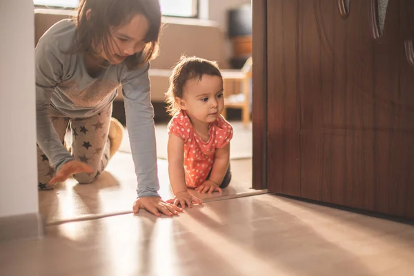 女の子は家で妹と遊ぶ 四つん這いで歩くのは楽しい — ストック写真