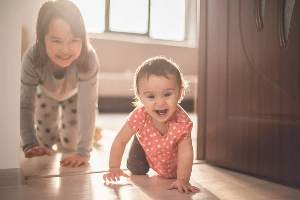 女孩在家里和她的小妹妹玩 他们四脚朝天 玩得很开心 — 图库照片