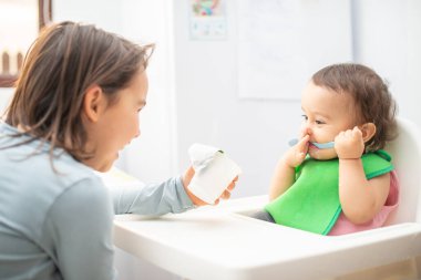 Büyük ablası küçük kardeşini besliyor ve eğleniyor..