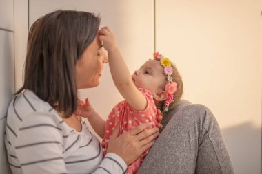 Sevgi dolu bir aile. Anne ve çocuk oynuyorlar, öpüşüyorlar ve sarılıyorlar.