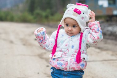 Küçük bir kızın portresi. Soğuk havada dağlarda eğleniyor.