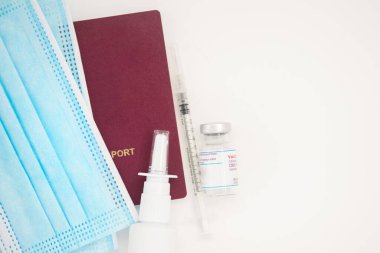 Uluslararası biyometrik COVID-19 aşı pasaportu, koruyucu maske, aşı şişesi ve şırınga aşısı.