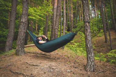 Ormanın kenarındaki bir hamakta duran bir adam manzaraya hayran.