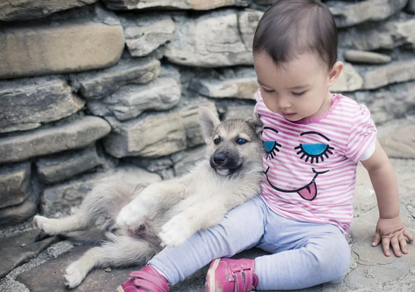 Bébé qui joue avec petit chien — Photo