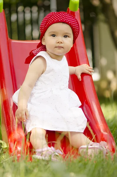 Linda niña jugando en la diapositiva — Foto de Stock