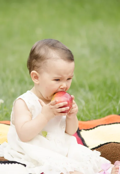 Kırmızı bir elma yiyen sevimli küçük kız — Stok fotoğraf