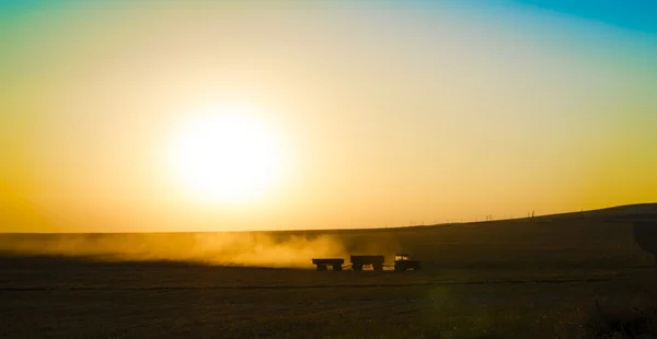 Traktor i sunrise plöja fältet — Stockfoto