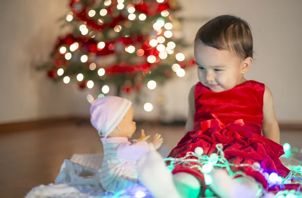 小さな女の子が彼女の最初クリスマスの贈り物で遊んで — ストック写真